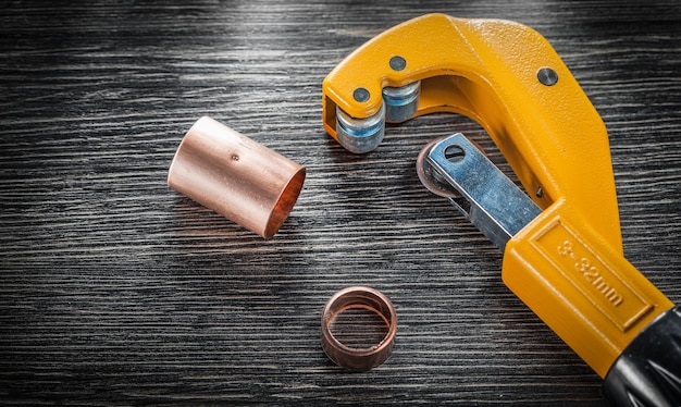 Copper water pipe cutter on wooden board.