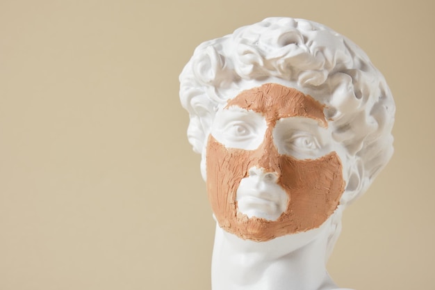 Фото Копия головы античной статуи давида с маской из косметической глины.