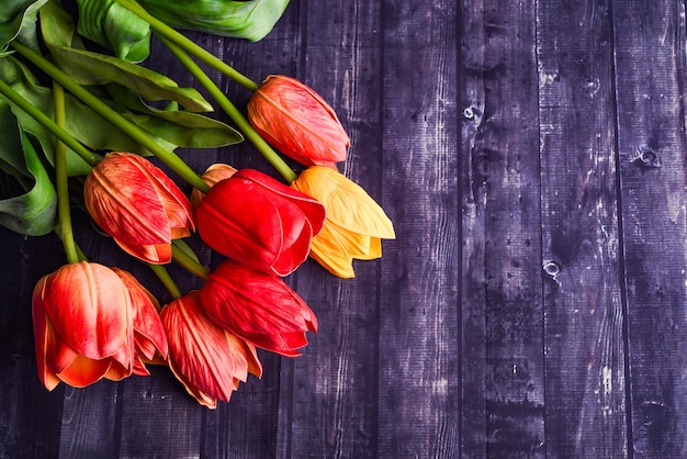 Copy space bouquet of orange and yellow tulips over a rustic wood table