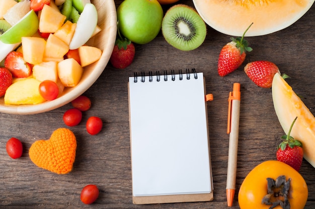 copy space on notebook paper and mixed fruits salad.