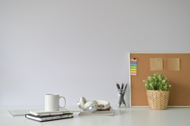 Copy space office desk with coffee mug, notebook and office supply with selective focus.