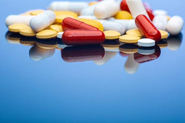 Copy space photo of pills lying in pile on blue background stock photo