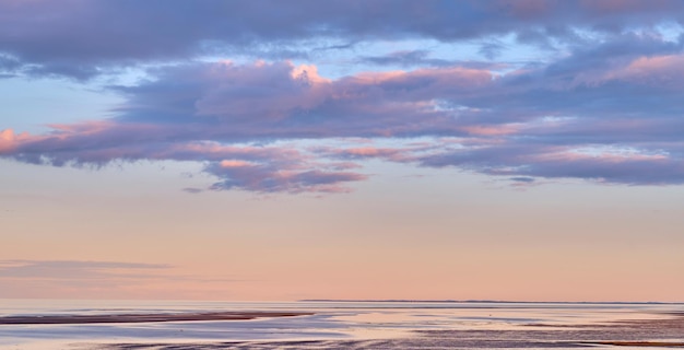 Copy space sea and ocean view with sunset sky and stratocumulus clouds over calm serene or peaceful beach Relaxing tropical and remote seascape with copyspace on private coastal island at sunrise