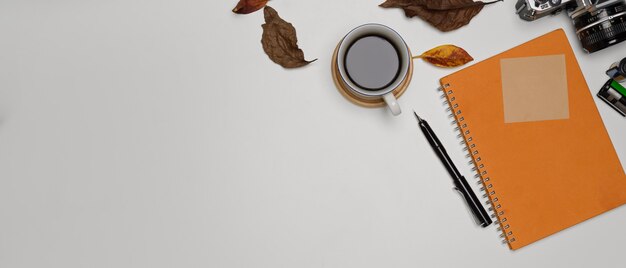 Copy space with diary coffee cup camera and leaves decorated on table