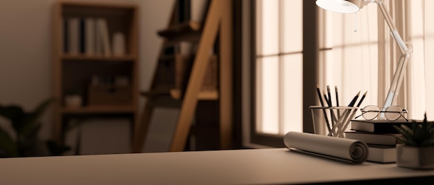 Copy space on working table over blurred home office background with table lamp a blue print roll