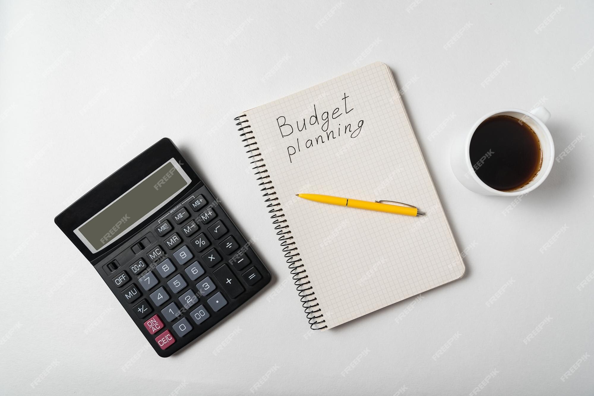 Premium Photo | Copybook with budget planning text notebook with calculator  and cup of coffee on white background top view