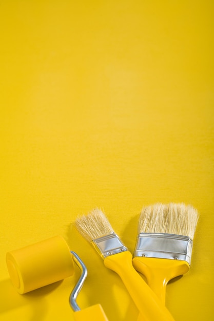 Copyspace image brushes and paintroller on a yellow background