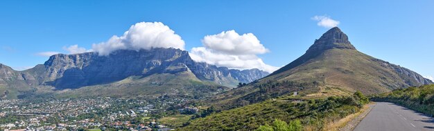 Copyspace with a mountain pass along Lions Head and Table Mountain in Cape Town South Africa against a cloudy sky background over a peninsula calm scenic landscape to travel explore on a road trip