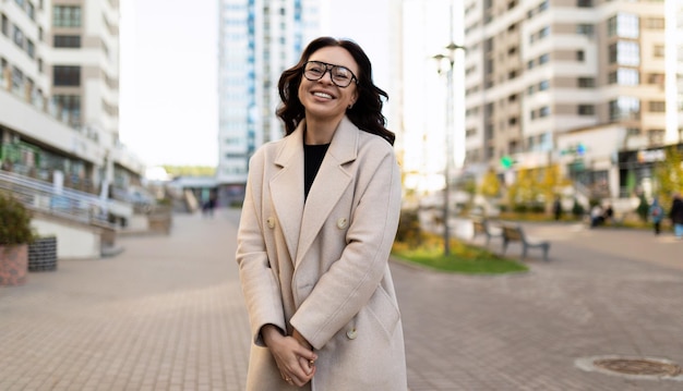 Coquettish young woman in business clothes smiling looking at camera outside