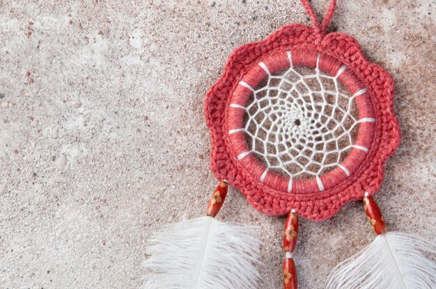 Coral dreamcatcher on concrete background