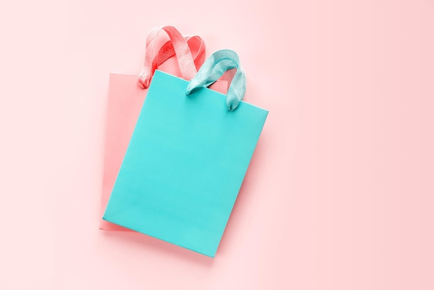 Coral and turquoise shopping bags on pink background with copy space for product placement and mock up