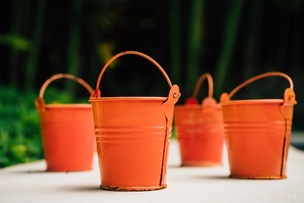 Coral watering buckets for plants in garden