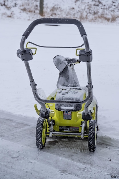 Cordless electric snowblower on driveway to clear snow in winter