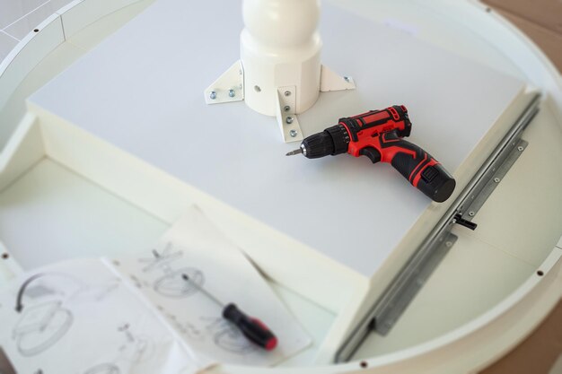 Cordless screwdriver on wood table assembly furniture concept