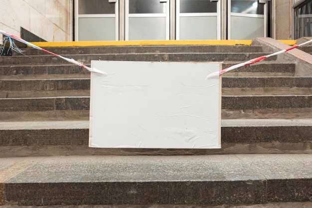 Cordon tape with empty informational cardboard hangs against
the steps forbidden staircase board barricade tape reminder safety
attach white forbid prohibited illegal unlawful