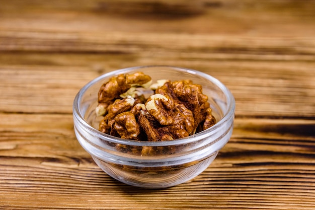 Cores of walnut in glass bowl on a wooden table