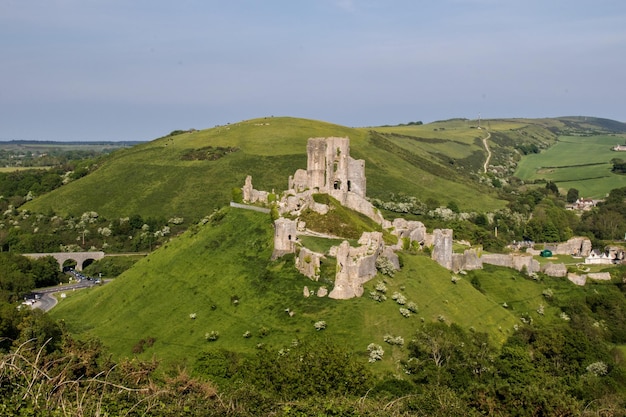 코르프 성 (Corfe castle) 은 도르 (Dorset) 의 하늘을 배경으로 산 위에 있다.