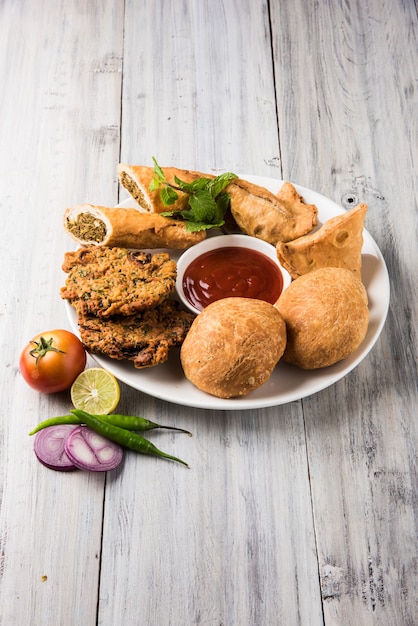 Coriander or Kothimbir vada, Samosa, Kachori, Daal Vada are favourite Indian tea time snacks. selective focus