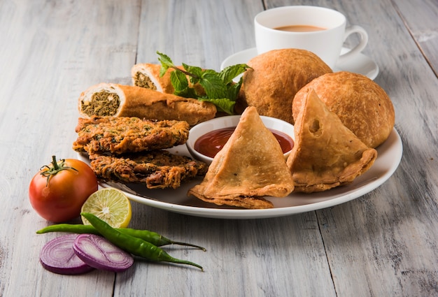 Coriander or Kothimbir vada, Samosa, Kachori, Daal Vada are favourite Indian tea time snacks. selective focus