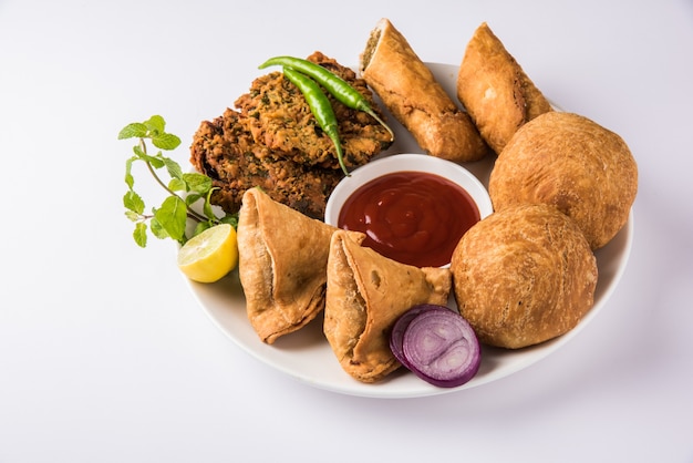 Coriander or Kothimbir vada, Samosa, Kachori, Daal Vada are favourite Indian tea time snacks. selective focus