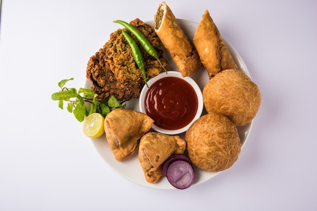 Coriander or Kothimbir vada, Samosa, Kachori, Daal Vada are favourite Indian tea time snacks. selective focus