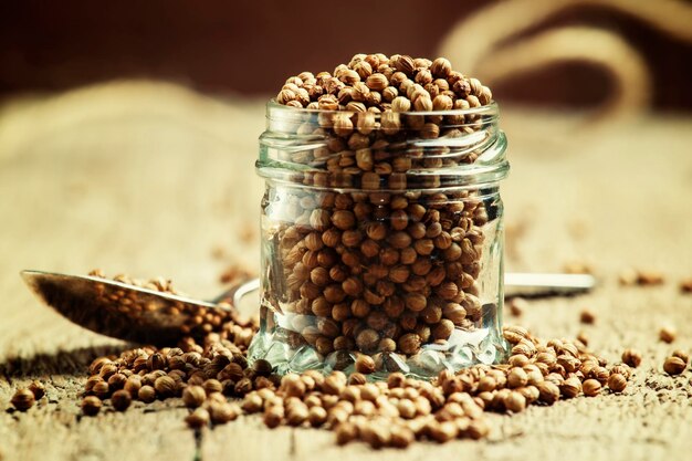 Coriander seeds in jar rustic style selective focus