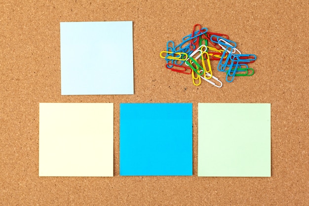 Cork board with several colorful blank notes with pins