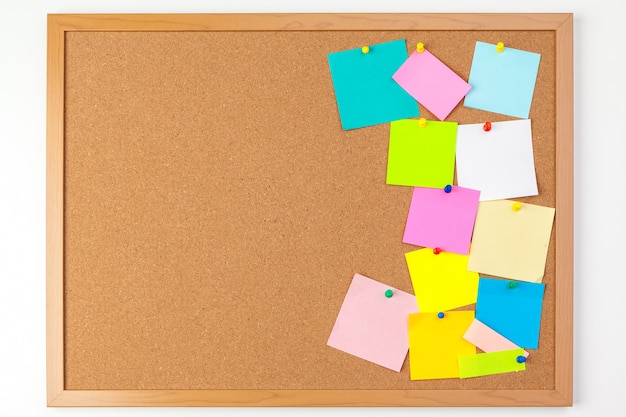 Photo cork board with several colorful blank notes with pins