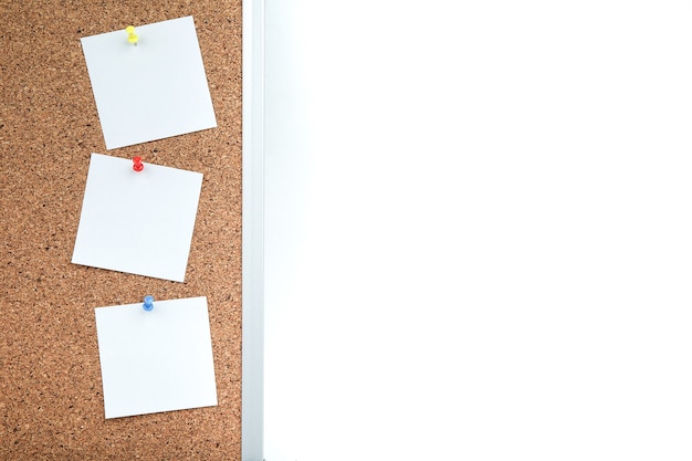 cork board with white empty notes of paper