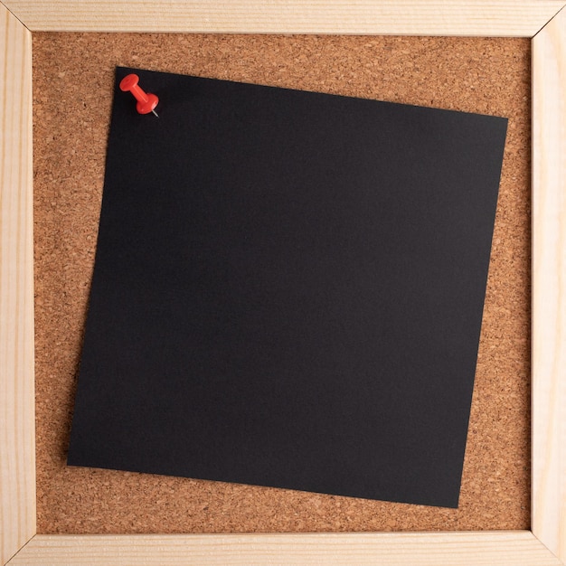 Cork note board with wooden frame with blank black square sheet for writing text