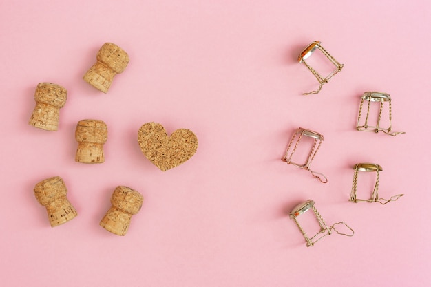 Corks and muselets from champagne and heart on pink