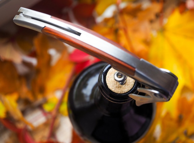 Corkscrew and bottle of red wine. Opening a bottle of wine. Close-up.