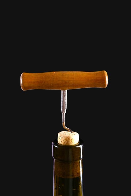 Corkscrew and wine bottle on a black background