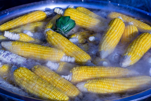 Photo corn boil in a saucepan on the street food market in thailand, close up