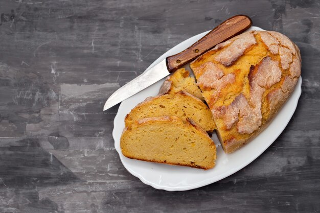 Pane di mais con coltello sul piatto bianco