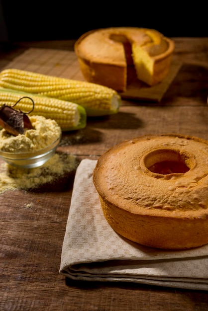 corn cake on rustic wooden table with corn slice in plate and cake in background