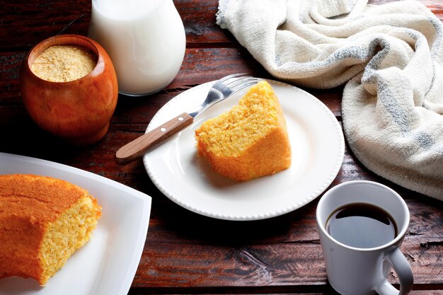 Photo corn cake with coconut white plate on rustic wooden table typical brazilian party food