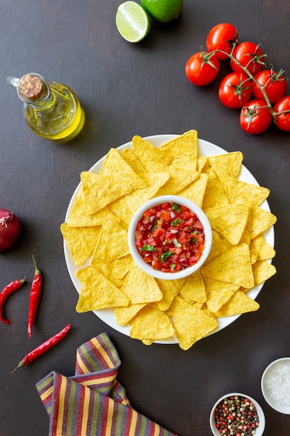 Corn chips nachos with salsa dip. mexican food. vegetarian\
food.
