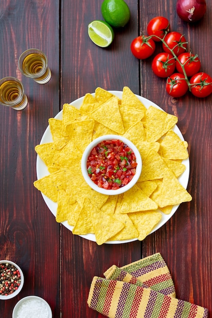 Corn chips nachos with salsa dip. mexican food. vegetarian\
food.