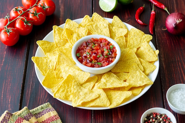 Corn chips nachos with salsa dip. mexican food. vegetarian\
food.