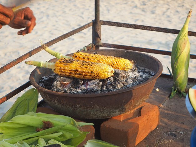 Corn on the cob is fried on coals with aromatic spices. Delicious and healthy snack in India