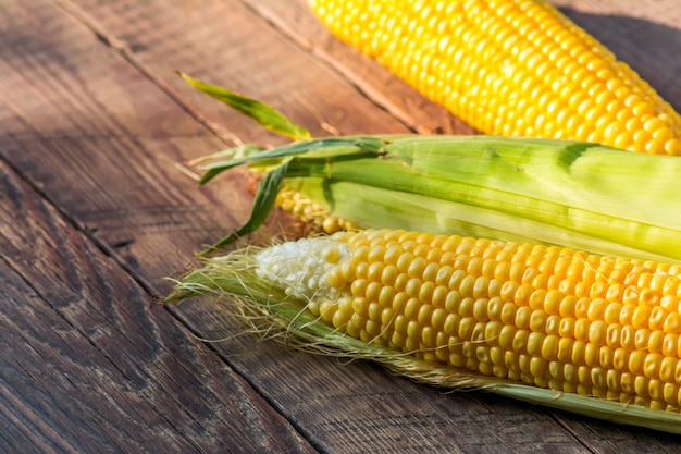 Corn cobs on wooden background