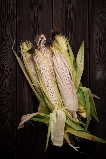 Corn cobs on a wooden table top view closeup rustic selective focus dairy corn