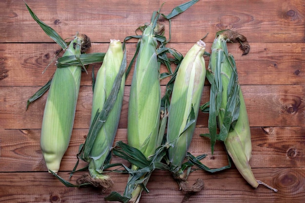 Corn on cobs on wooden tableTop view