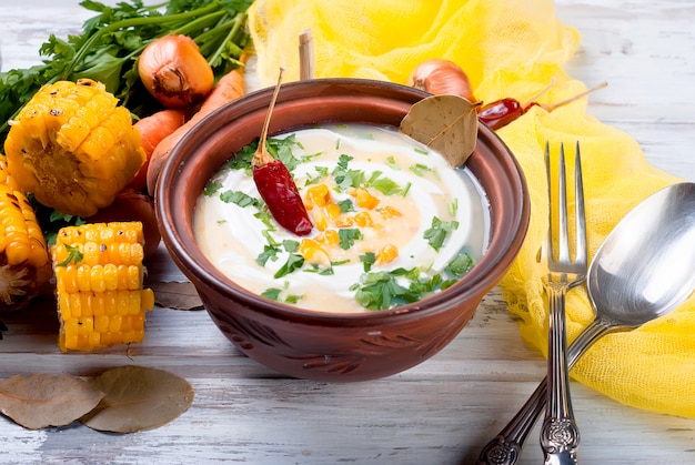 Corn cream soup with sour cream and herbs