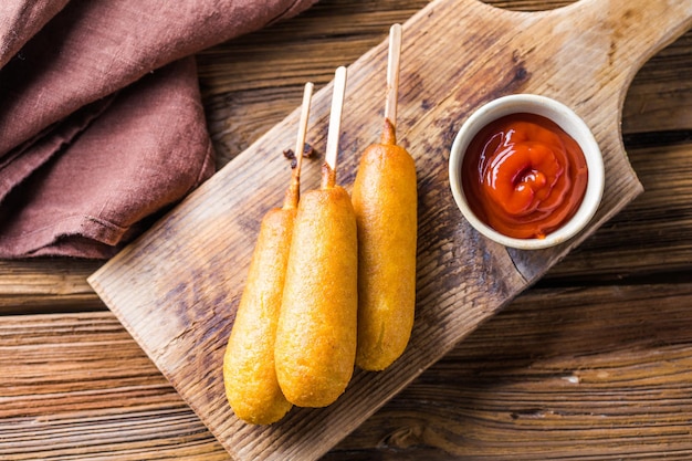 Corn dogs of worst in rol met ketchup Top view tafel scène over een houten achtergrond