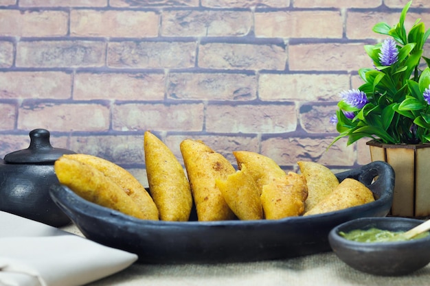 Corn empanada typical Colombian food with spicy sauce