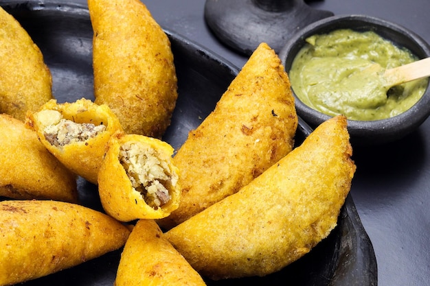 Corn empanada typical Colombian food with spicy sauce