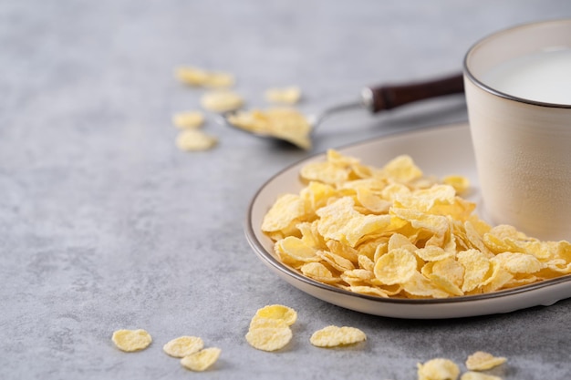 Corn flakes bowl sweeties with milk on gray cement background close up fresh and healthy breakbast design concept