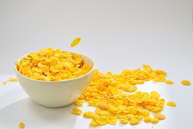 Corn flakes falling to the white bowl. Motion. Copyspace.